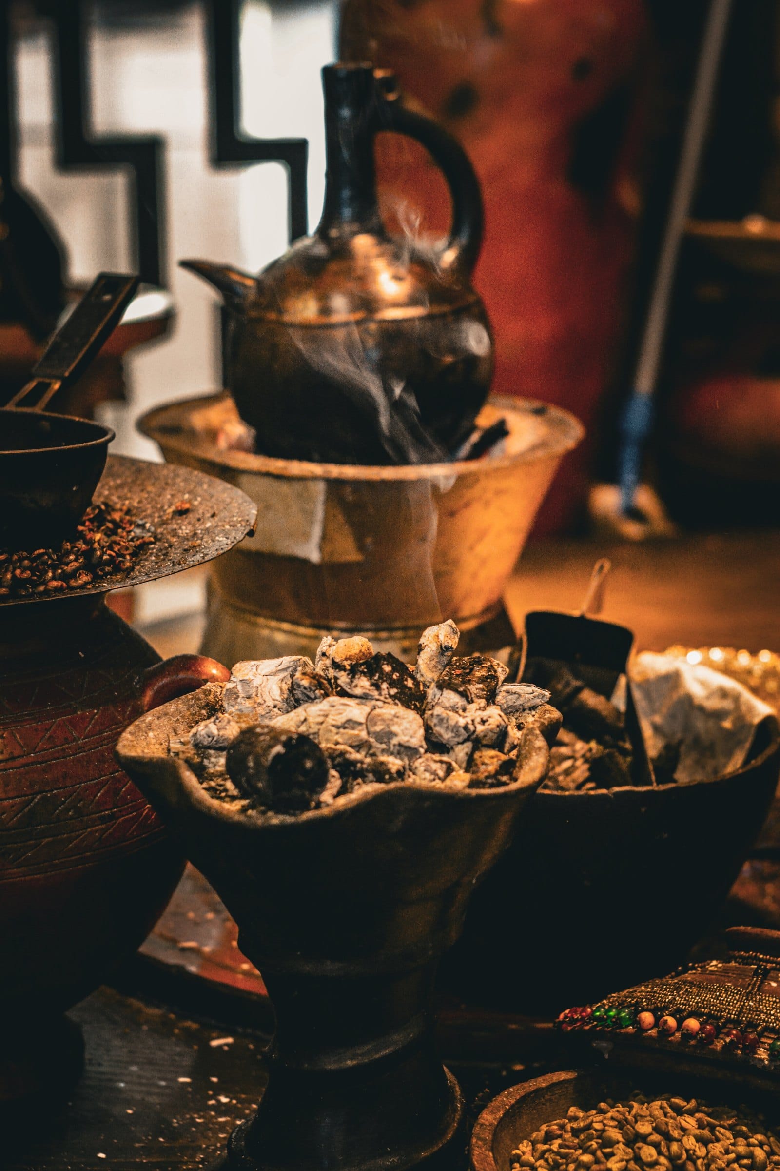 A jebena coffee pot and cups in warm evening light