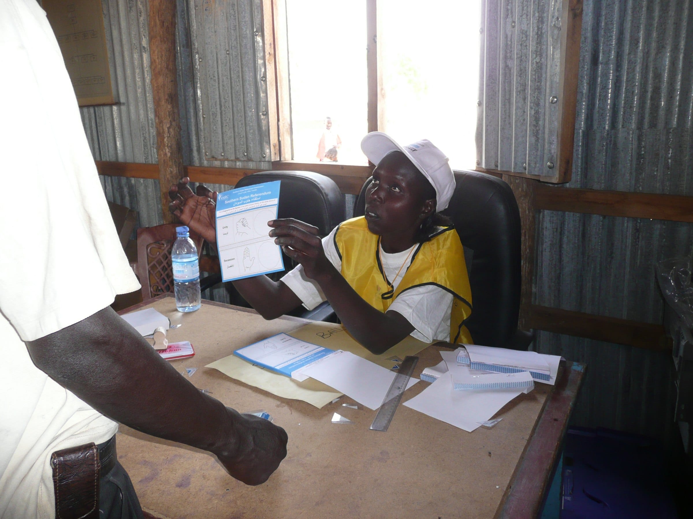 A polling official explains to a voter how to cast a ballot