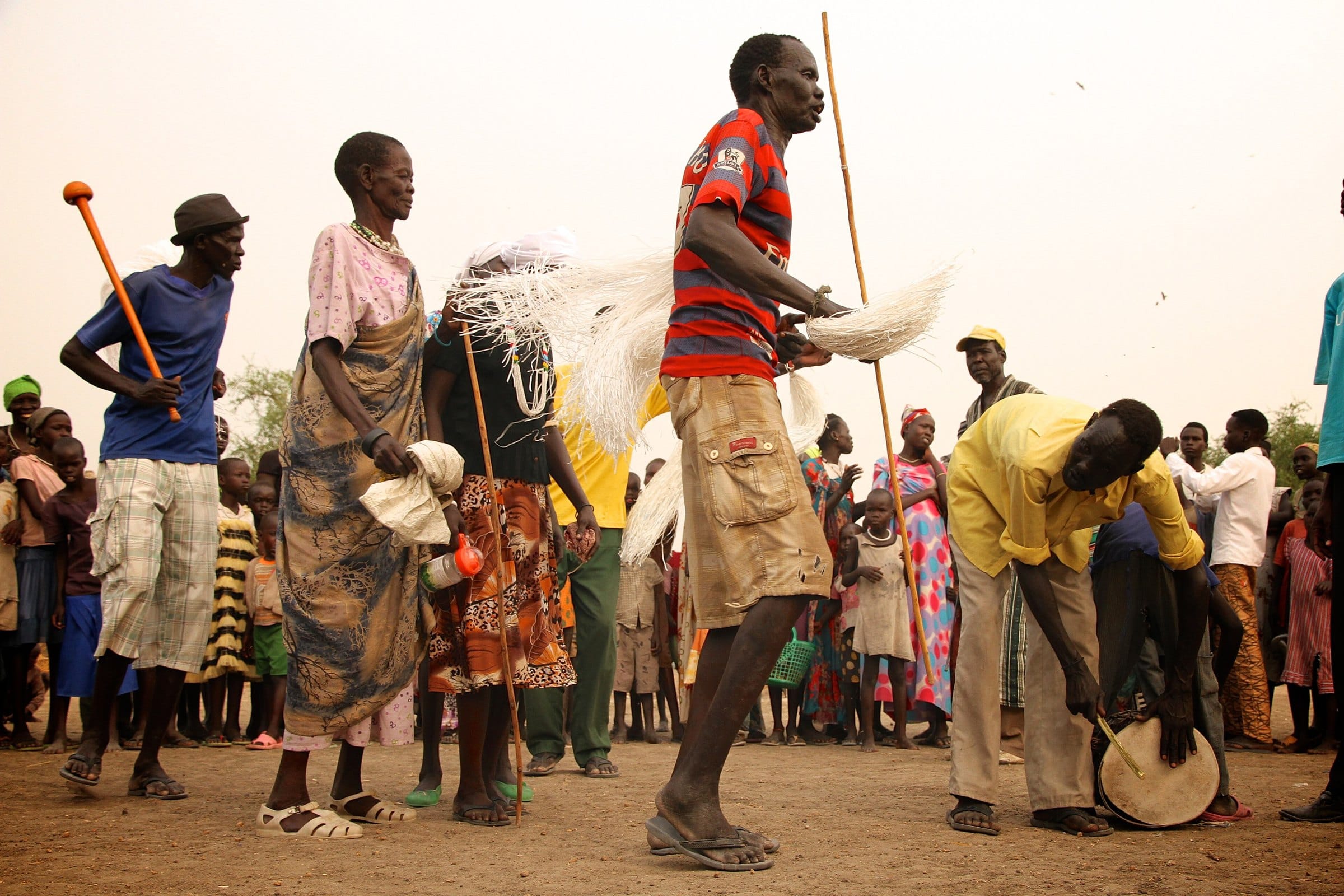 A community arts group performs for a crowd, with a megaphone